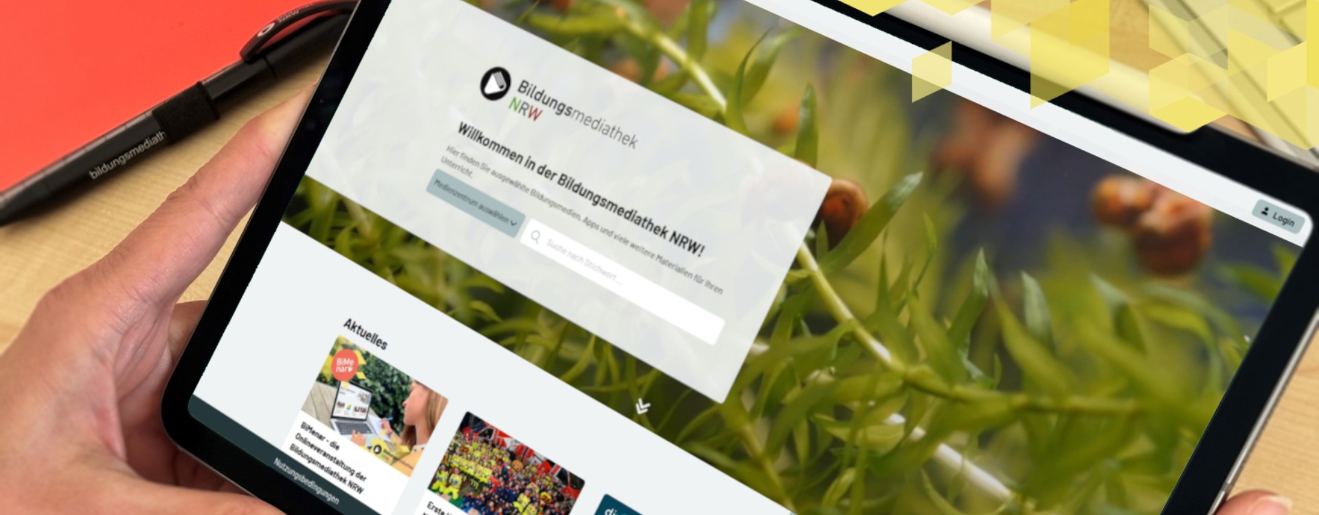 Person hält ein Tablet in der Hand und schaut sich die neue Startseite der Bildungsmediathek NRW an